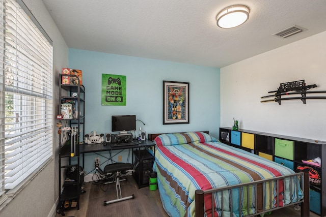 bedroom with wood-type flooring and a textured ceiling