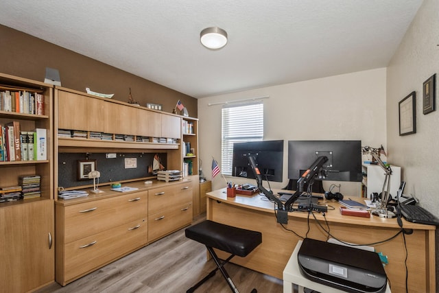 home office featuring a textured ceiling and light hardwood / wood-style flooring