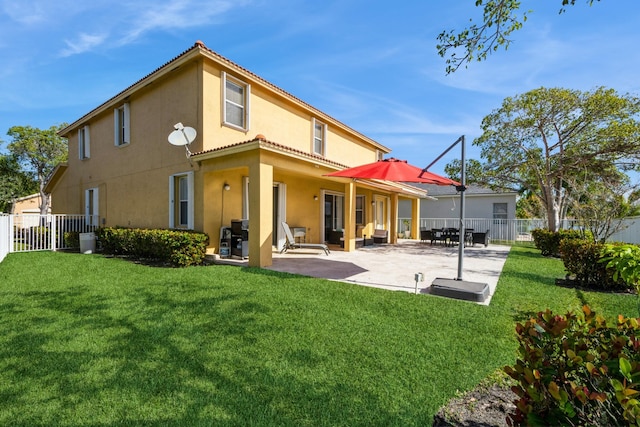 rear view of house with a yard and a patio