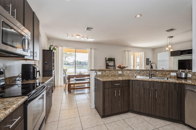 kitchen featuring light stone countertops, sink, dark brown cabinetry, and stainless steel appliances