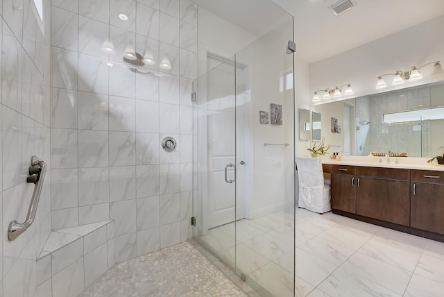 full bathroom featuring vanity, a shower stall, and visible vents