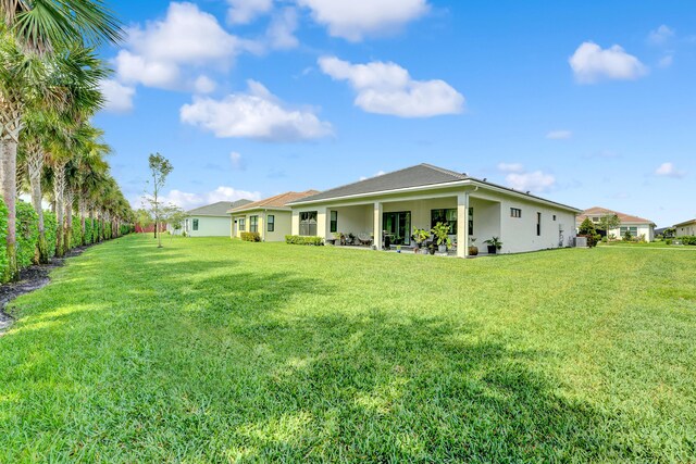 back of house featuring a yard, a patio, and central air condition unit