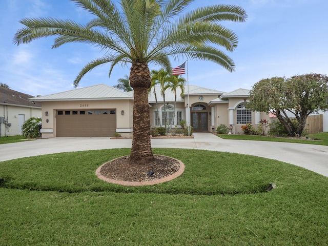 view of front of house with french doors, a front yard, and a garage