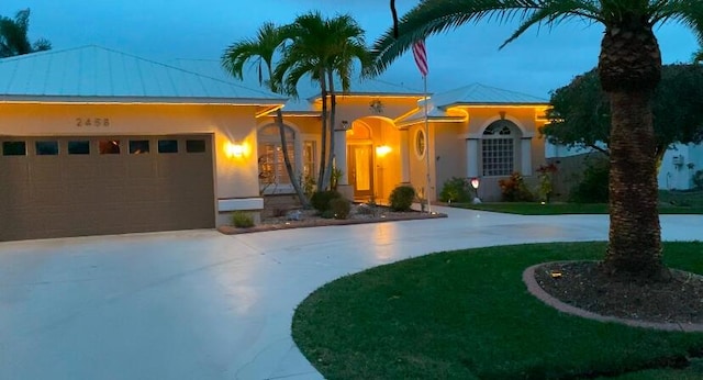 view of front of property featuring a garage and a lawn