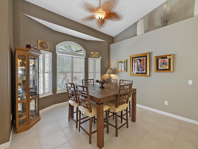 dining space featuring vaulted ceiling, light tile patterned floors, and ceiling fan