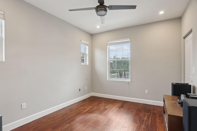 home office with ceiling fan and dark hardwood / wood-style flooring