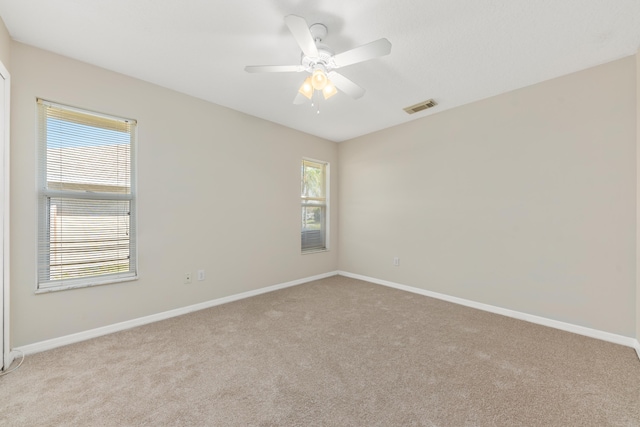 carpeted spare room with ceiling fan and a healthy amount of sunlight