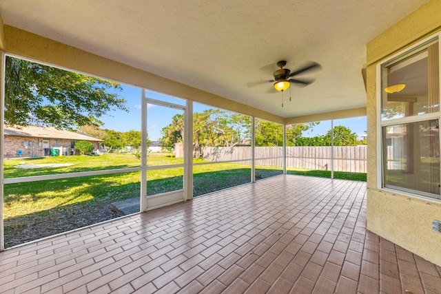 unfurnished sunroom featuring ceiling fan