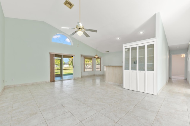 tiled empty room with ceiling fan and high vaulted ceiling