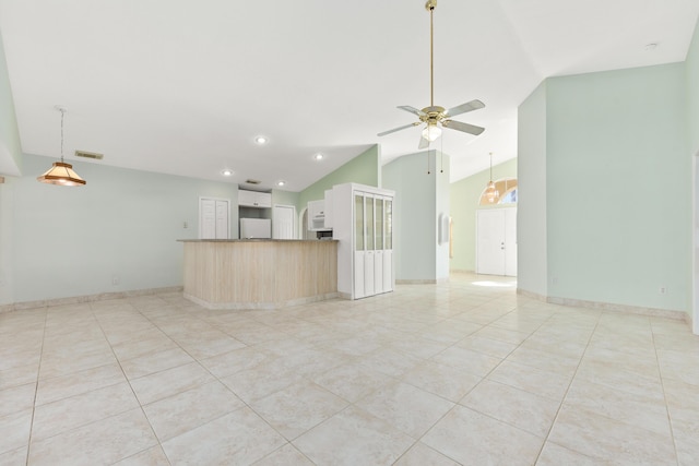 unfurnished living room with ceiling fan, vaulted ceiling, and light tile patterned flooring