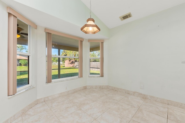 tiled empty room featuring lofted ceiling and a healthy amount of sunlight