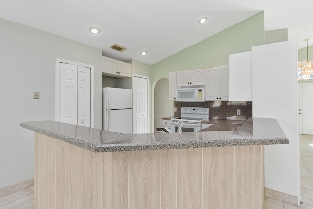 kitchen with kitchen peninsula, tasteful backsplash, white appliances, light tile patterned flooring, and lofted ceiling