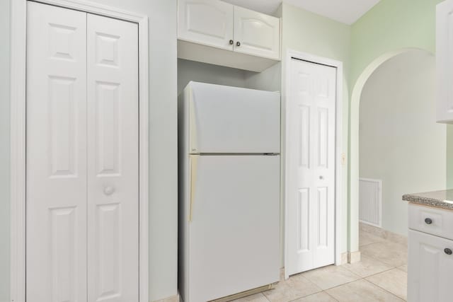 kitchen with white cabinetry, light tile patterned floors, and white refrigerator