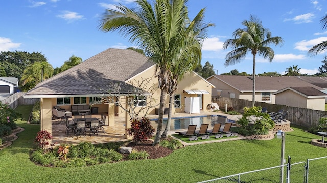 back of property featuring a yard, a fenced in pool, and a patio area