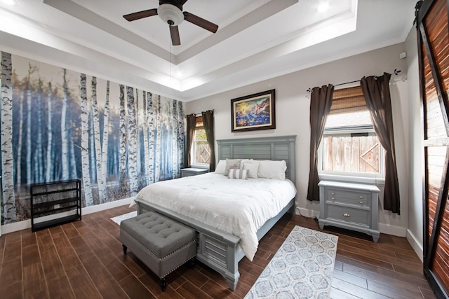 bedroom featuring a raised ceiling, crown molding, ceiling fan, and dark hardwood / wood-style flooring