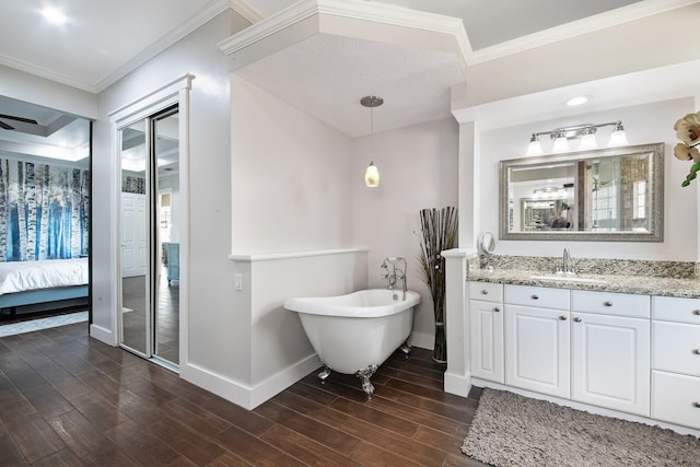 bathroom featuring hardwood / wood-style flooring, vanity, crown molding, and a tub