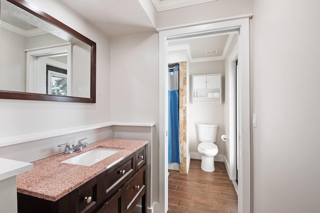 bathroom featuring vanity, ornamental molding, and toilet