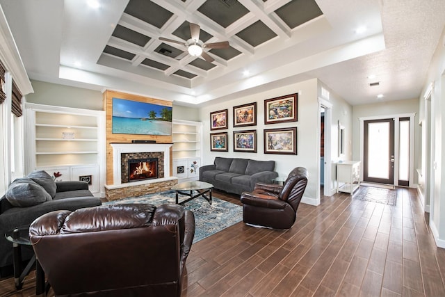 living room with dark hardwood / wood-style floors, built in features, a fireplace, coffered ceiling, and beam ceiling