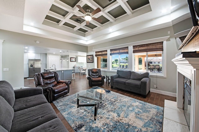 living room featuring coffered ceiling, a towering ceiling, a high end fireplace, beam ceiling, and hardwood / wood-style floors