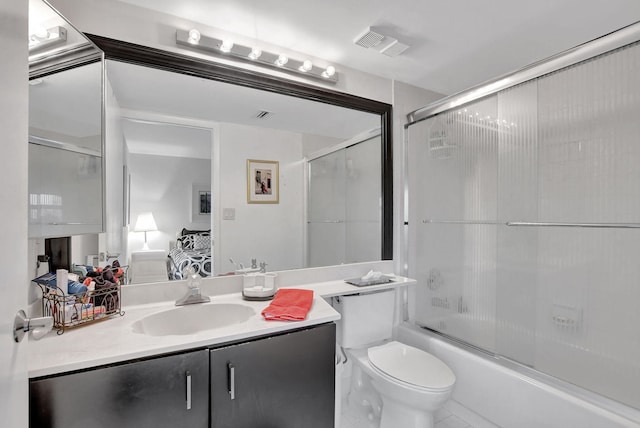 full bathroom featuring vanity, toilet, and bath / shower combo with glass door