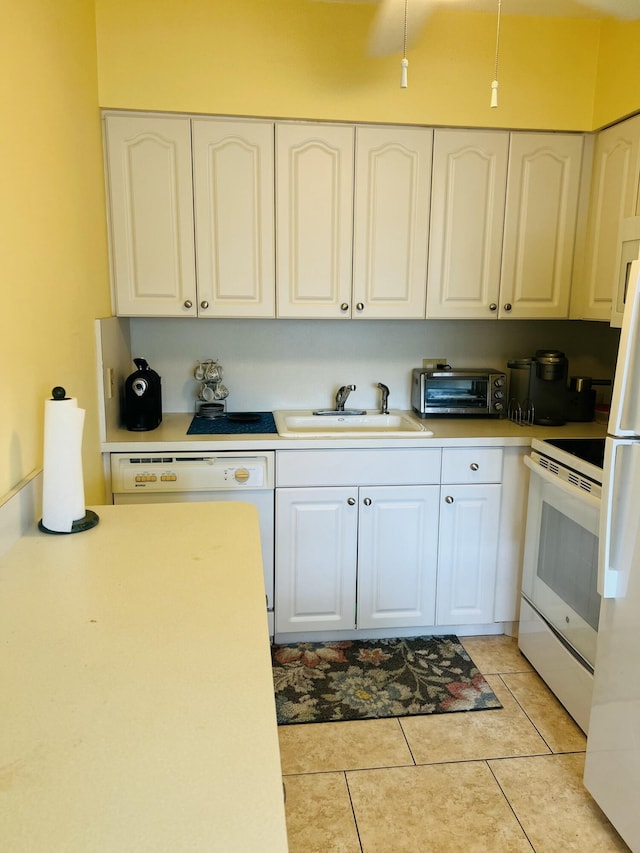 kitchen featuring white cabinets, light tile patterned floors, sink, and white appliances