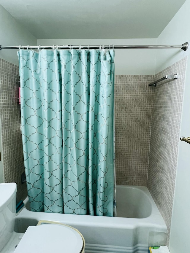 bathroom with toilet and shower / bath combo with shower curtain