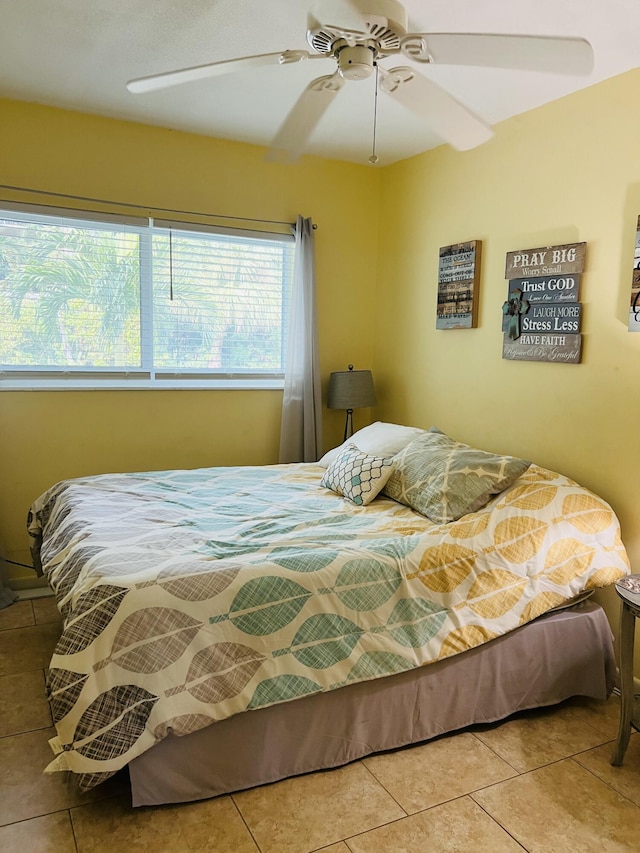 bedroom with ceiling fan and tile patterned flooring