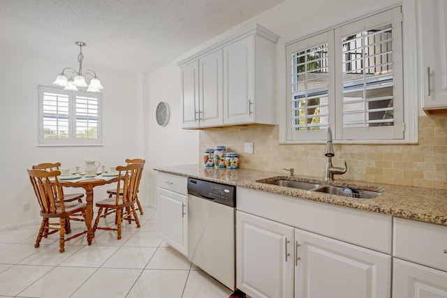 kitchen featuring stainless steel dishwasher, sink, white cabinetry, light tile patterned floors, and a chandelier