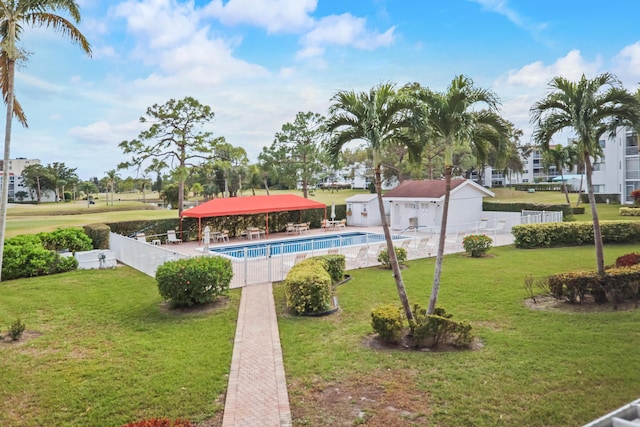 exterior space featuring an outbuilding, a lawn, a patio area, and a pool