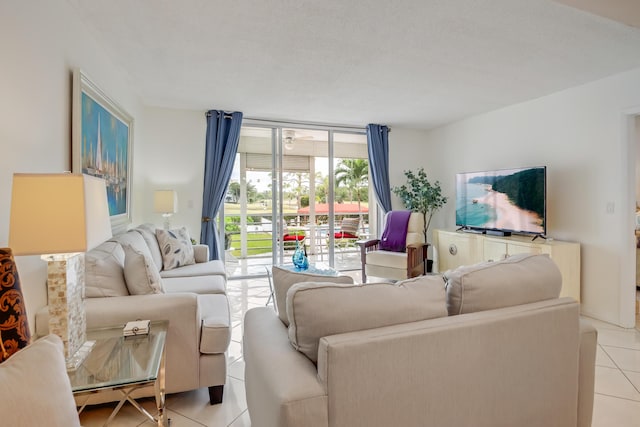 tiled living room with ceiling fan and a wall of windows