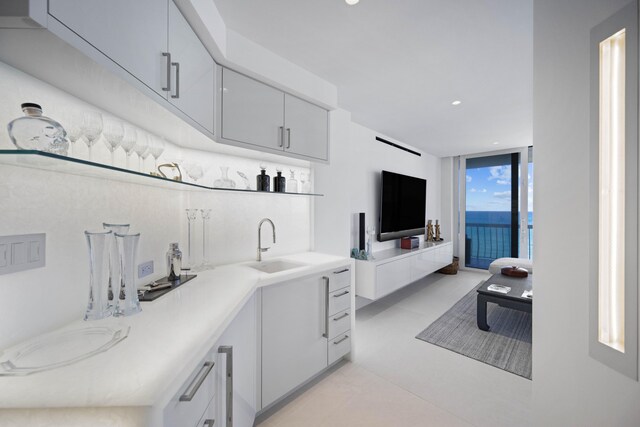 kitchen featuring light tile patterned floors, sink, and floor to ceiling windows