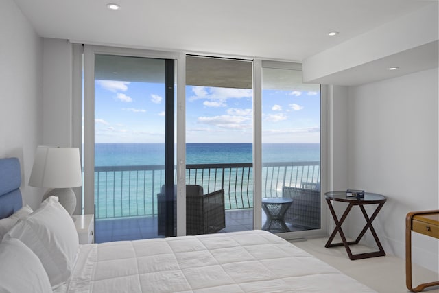 bedroom featuring expansive windows, access to outside, a water view, and light tile patterned flooring