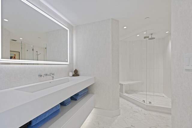 bathroom featuring a shower with shower door and vanity