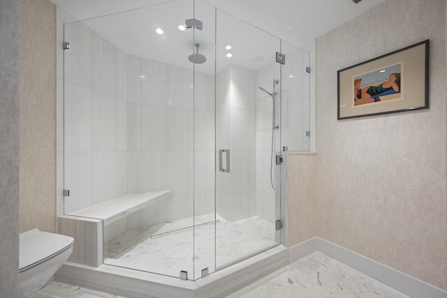 bathroom featuring a shower with shower door and toilet