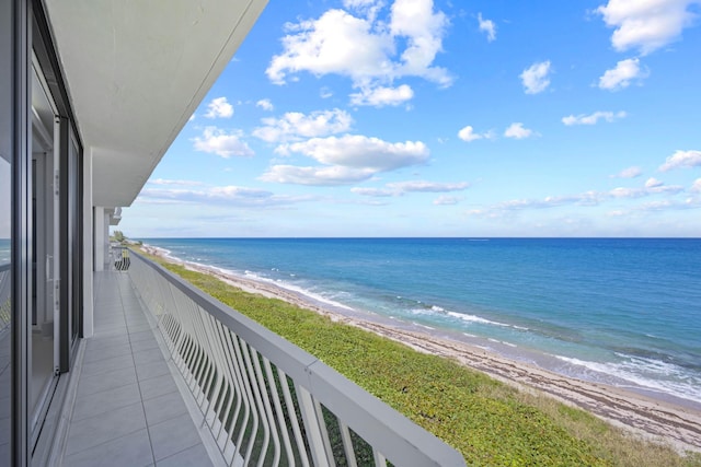 balcony featuring a water view and a beach view