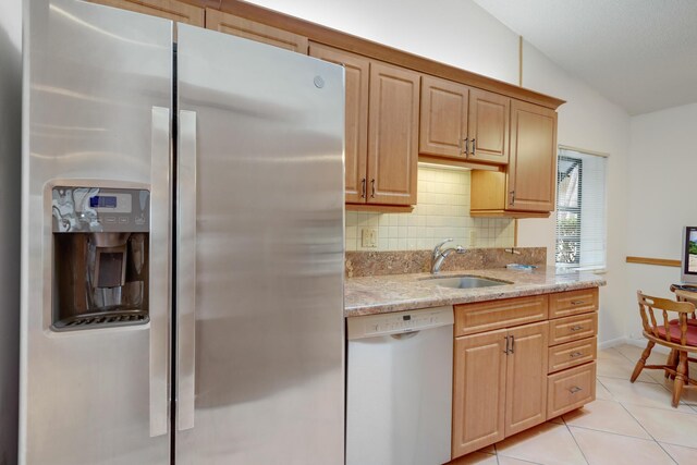 kitchen with white electric stove, light tile patterned floors, under cabinet range hood, stainless steel microwave, and lofted ceiling with skylight