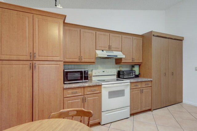 kitchen featuring backsplash, dishwasher, sink, light tile patterned flooring, and light stone countertops