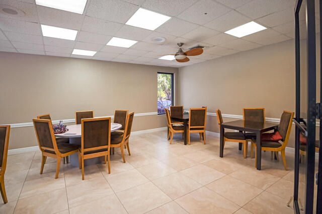 tiled dining space with a paneled ceiling and ceiling fan