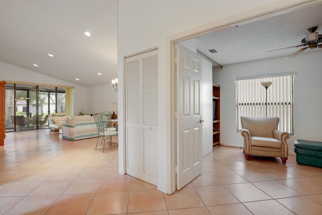 hallway featuring light tile patterned floors and lofted ceiling