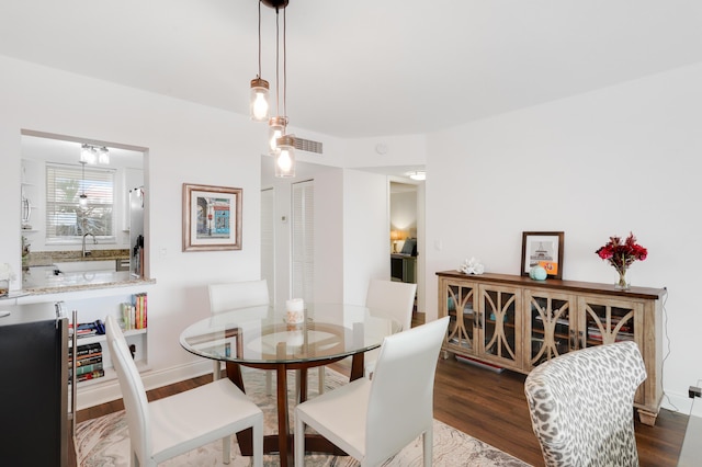 dining room with dark hardwood / wood-style floors and sink