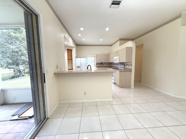 kitchen with kitchen peninsula, light brown cabinets, backsplash, white appliances, and sink