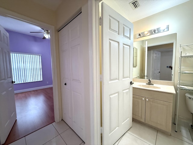 bathroom with toilet, ceiling fan, tile patterned floors, a textured ceiling, and vanity