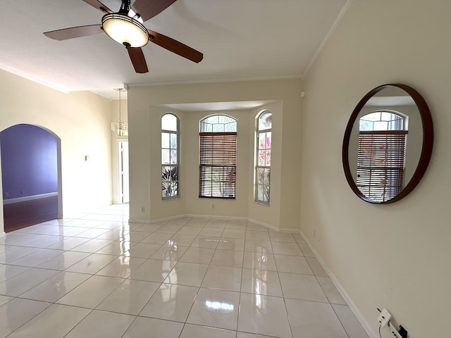 tiled empty room with crown molding, a healthy amount of sunlight, and ceiling fan