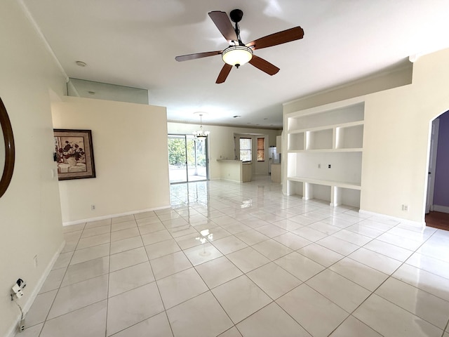 spare room featuring ceiling fan with notable chandelier and light tile patterned floors