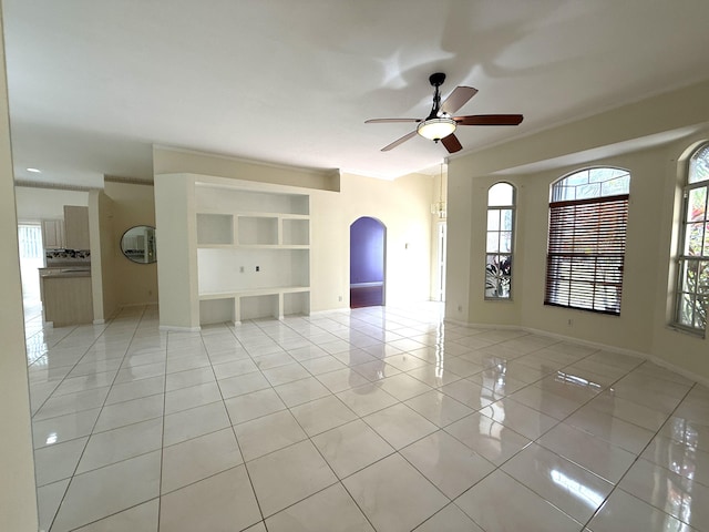 tiled spare room featuring ceiling fan and a healthy amount of sunlight