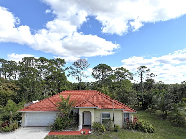 mediterranean / spanish house with a front lawn and a garage