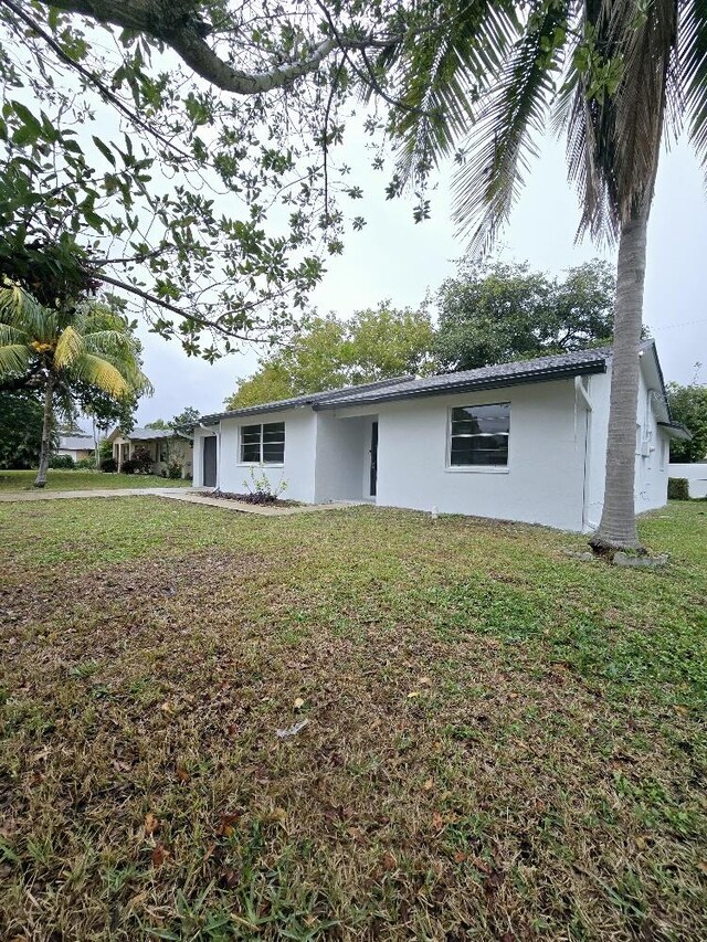 ranch-style home featuring a front lawn