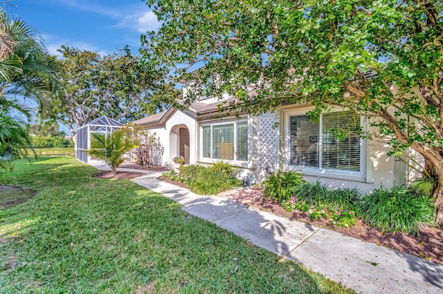 view of front of home featuring a lanai and a front lawn