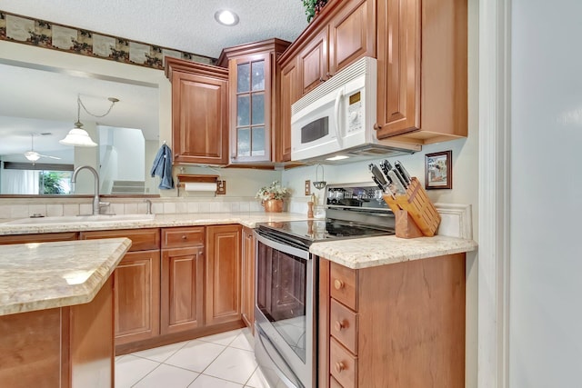 kitchen featuring ceiling fan, sink, hanging light fixtures, stainless steel range with electric cooktop, and light tile patterned floors