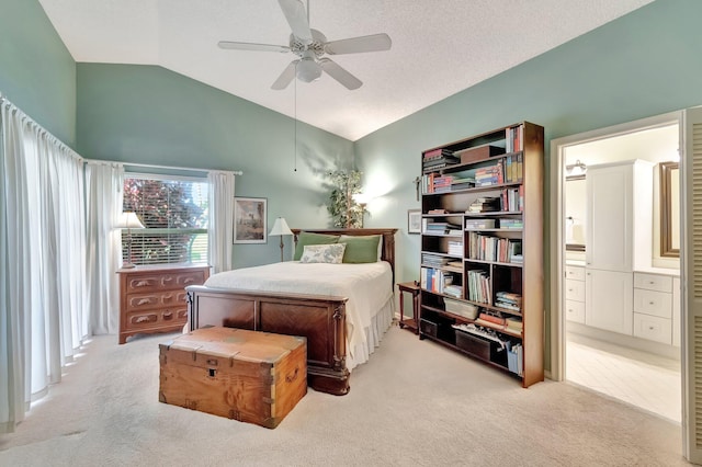 bedroom featuring a textured ceiling, lofted ceiling, connected bathroom, light carpet, and ceiling fan